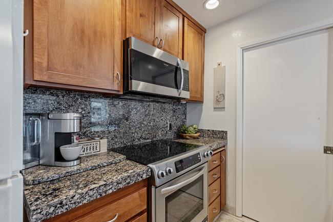 101 Shell Road, Unit 102 Watsonville, CA 95076 - Photo 10 of 34 a kitchen with granite countertop a stove top oven microwave and cabinets
