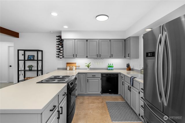 a kitchen with a refrigerator a sink and wooden cabinets