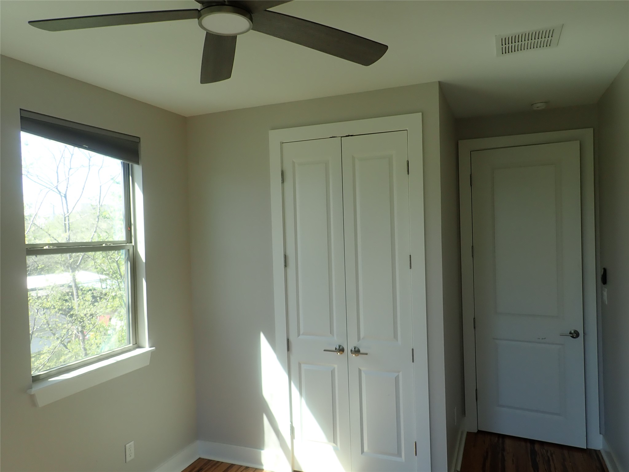 2912 East 14th Street, Unit A Austin, TX 78702 - Photo 24 of 27 Bedroom featuring dark wood-type flooring, a closet, and ceiling fan