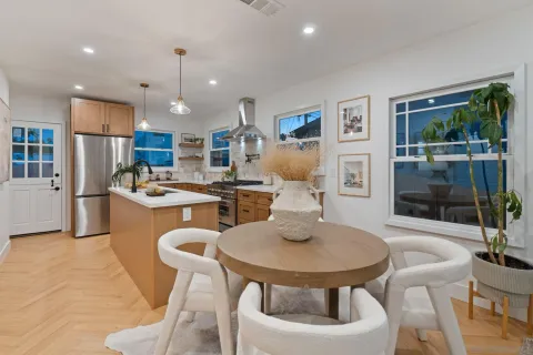 a kitchen with a sink a refrigerator and chairs