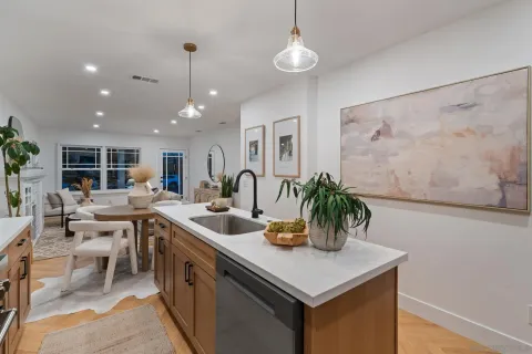 a kitchen with a sink dining table and chairs