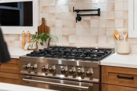 a stove top oven sitting inside of a kitchen