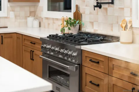 a stove top oven sitting inside of a kitchen
