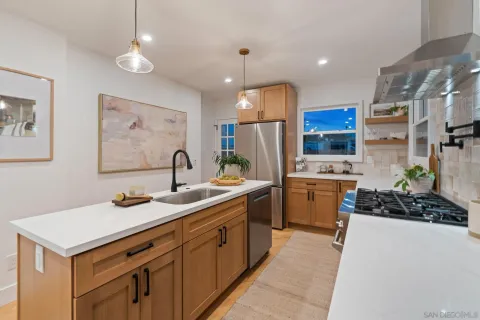 a kitchen that has a lot of cabinets a sink and a stove