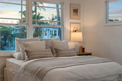 a large bed sitting in a bedroom next to a window