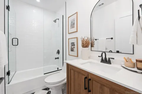 a bathroom with a granite countertop sink toilet tub and shower