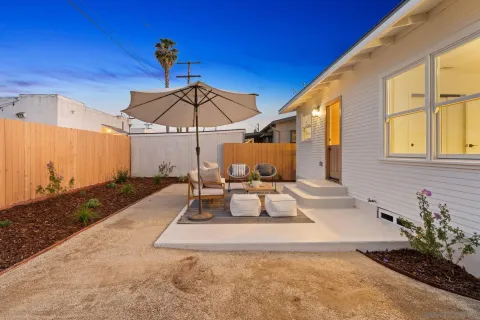 a view of a patio with a table and chairs under an umbrella