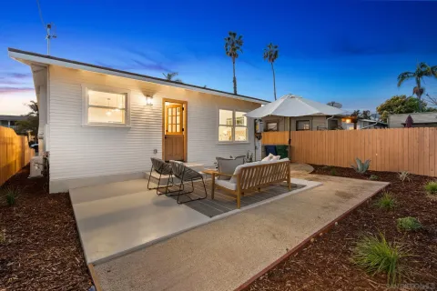 a backyard of a house with table and chairs