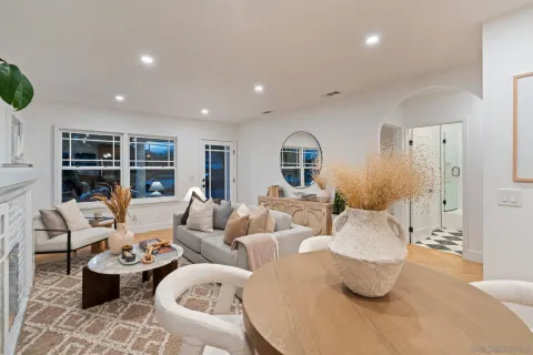 a living room with furniture kitchen view and a large window