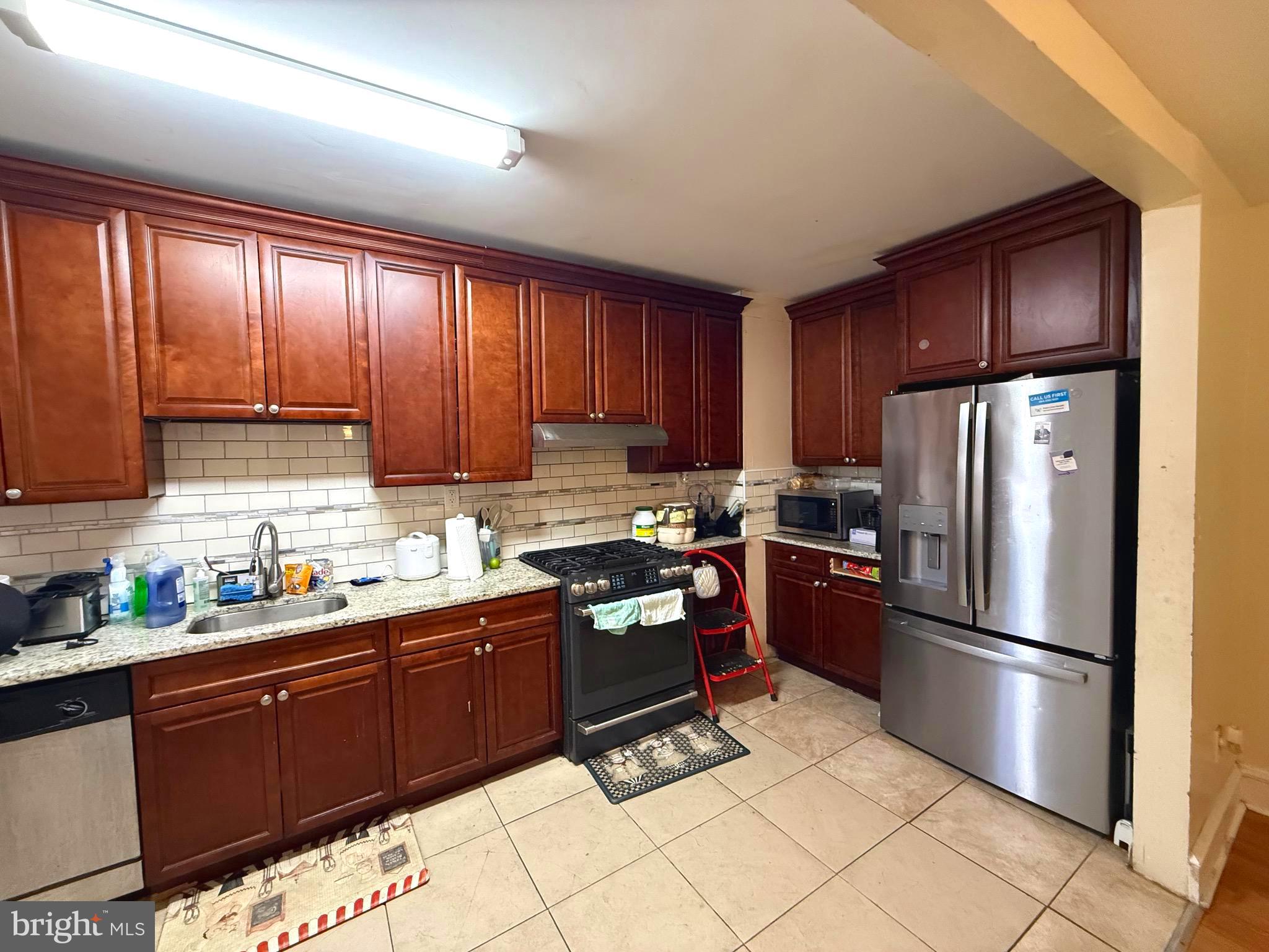 212 North Maple Avenue Lansdowne, PA 19050 - Photo 3 of 29 a kitchen with granite countertop wooden cabinets and stainless steel appliances