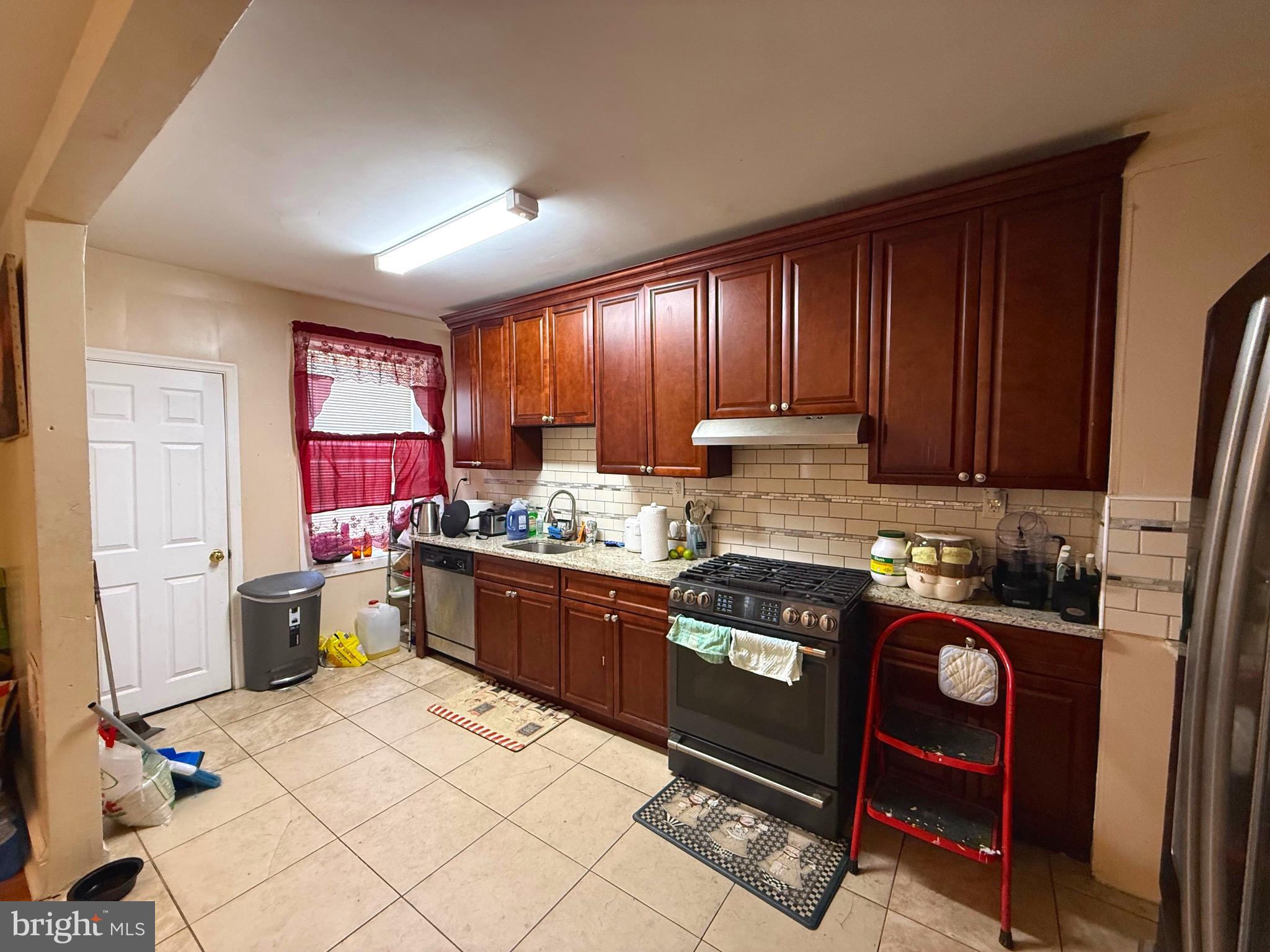 212 North Maple Avenue Lansdowne, PA 19050 - Photo 4 of 29 a kitchen with a stove a refrigerator and wooden cabinets