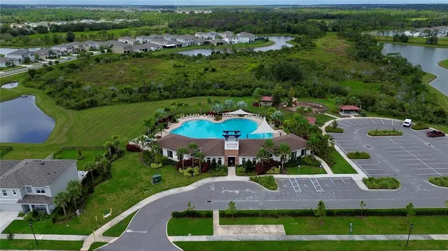 an aerial view of a house with a garden and lake view
