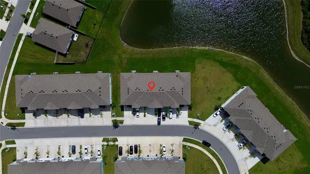 an aerial view of a swimming pool with outdoor space and seating