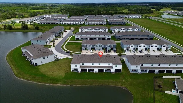 an aerial view of a house with a garden and lake view