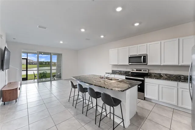 a kitchen with stainless steel appliances granite countertop a stove top oven a sink a counter top space and cabinets