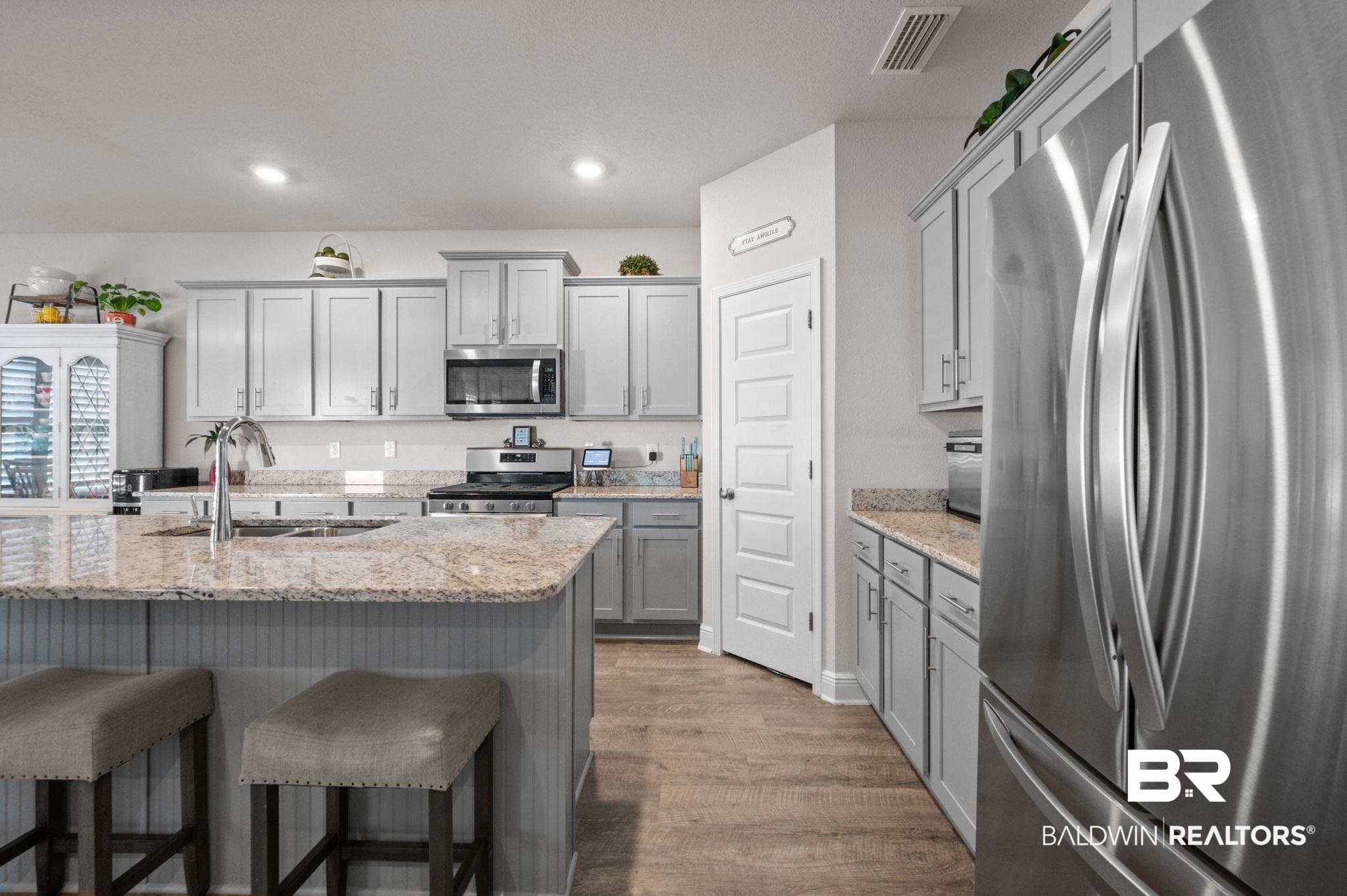 24891 Spectacular Bid Loop Daphne, AL 36526 - Photo 17 of 51 Kitchen featuring gray cabinets, hardwood / wood-style floors, sink, stainless steel appliances, and light stone countertops