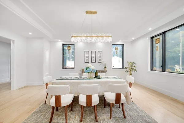 a view of a a dining room with furniture window and wooden floor