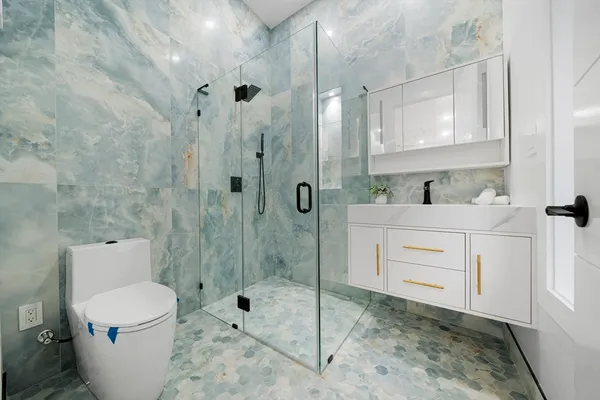 a bathroom with a sink a toilet and shower