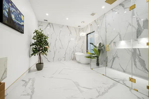 a large white room with a potted plant and a large window