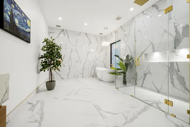 a large white room with a potted plant and a large window