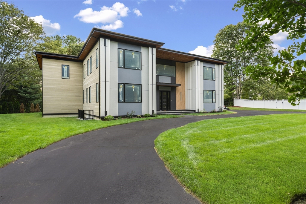 197 Woburn Street Lexington, MA 02420 - Photo 3 of 42 a front view of a house with a yard and garage