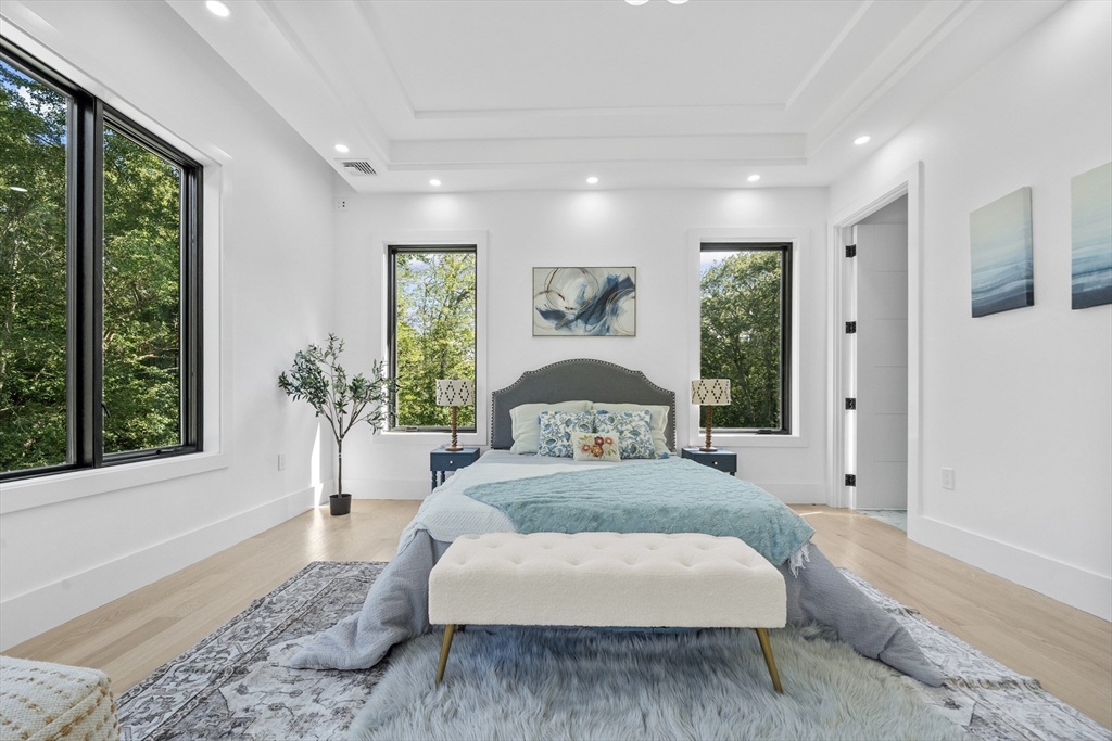 197 Woburn Street Lexington, MA 02420 - Photo 32 of 42 a spacious bedroom with a large bed and a potted plant