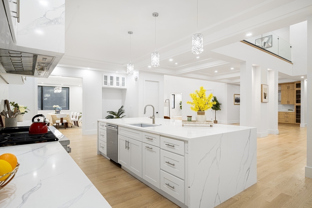 197 Woburn Street Lexington, MA 02420 - Photo 10 of 42 a large white kitchen with a large counter space and wooden floor