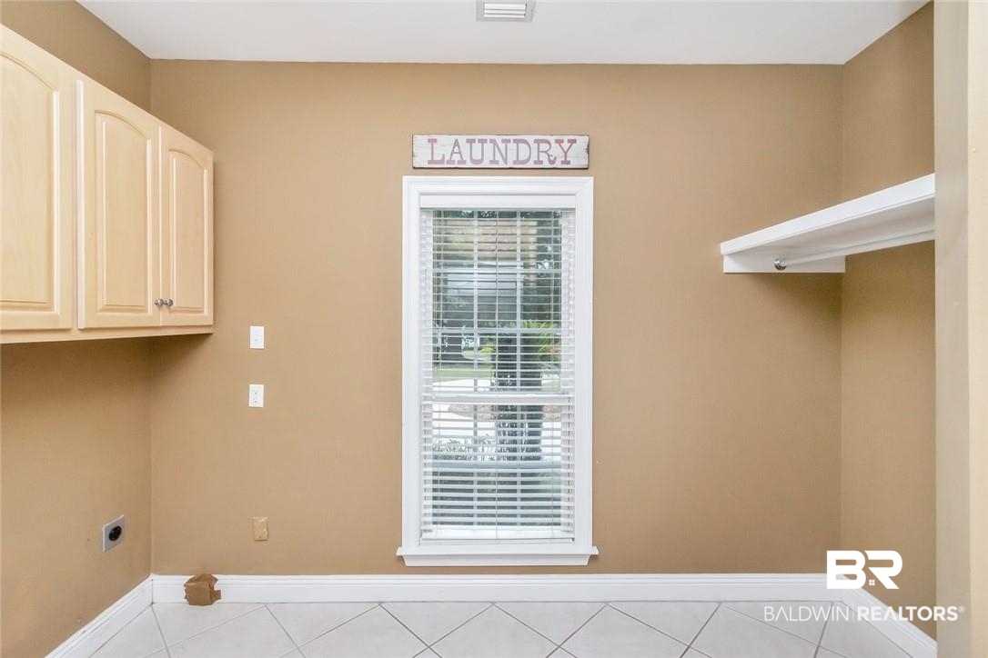 8837 Dawes Lake Road South Mobile, AL 36619 - Photo 33 of 44 Laundry room with hookup for an electric dryer, cabinets, and light tile patterned flooring