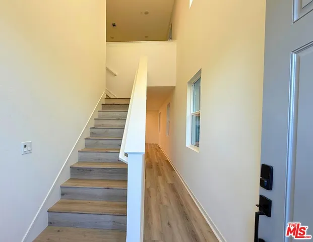 a view of staircase with railing and white walls
