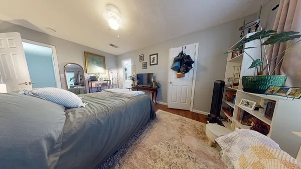 a bedroom with a bed a mirror and dresser