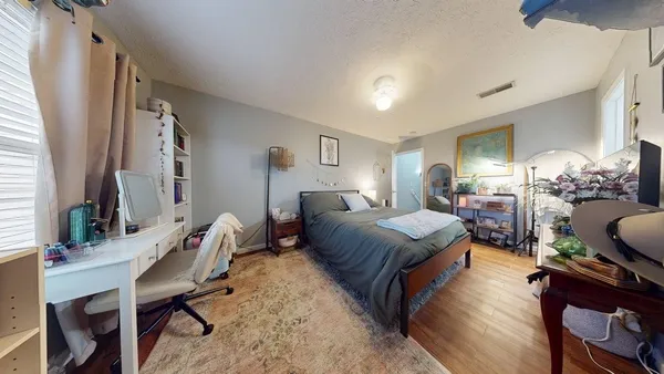 a bedroom with a bed window and chair