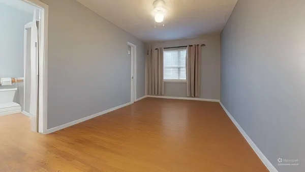 a view of empty room with wooden floor