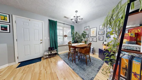 a view of a dining room with furniture a rug and wooden floor