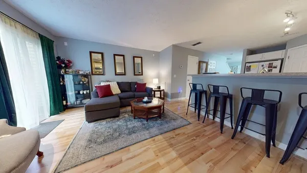 a living room with furniture and a wooden floor