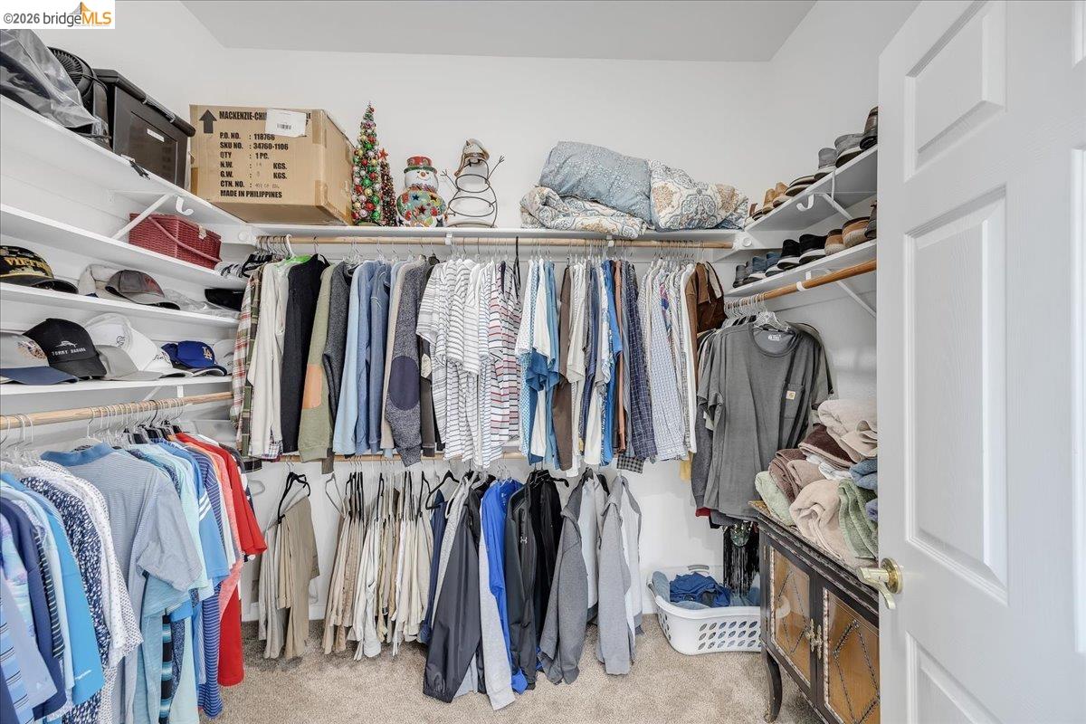 158 Rock Ridge Lane Copperopolis, CA 95228 - Photo 39 of 72 Walk-in closet featuring extensive built-in shelving, multiple hanging rods, and neutral-toned carpeting