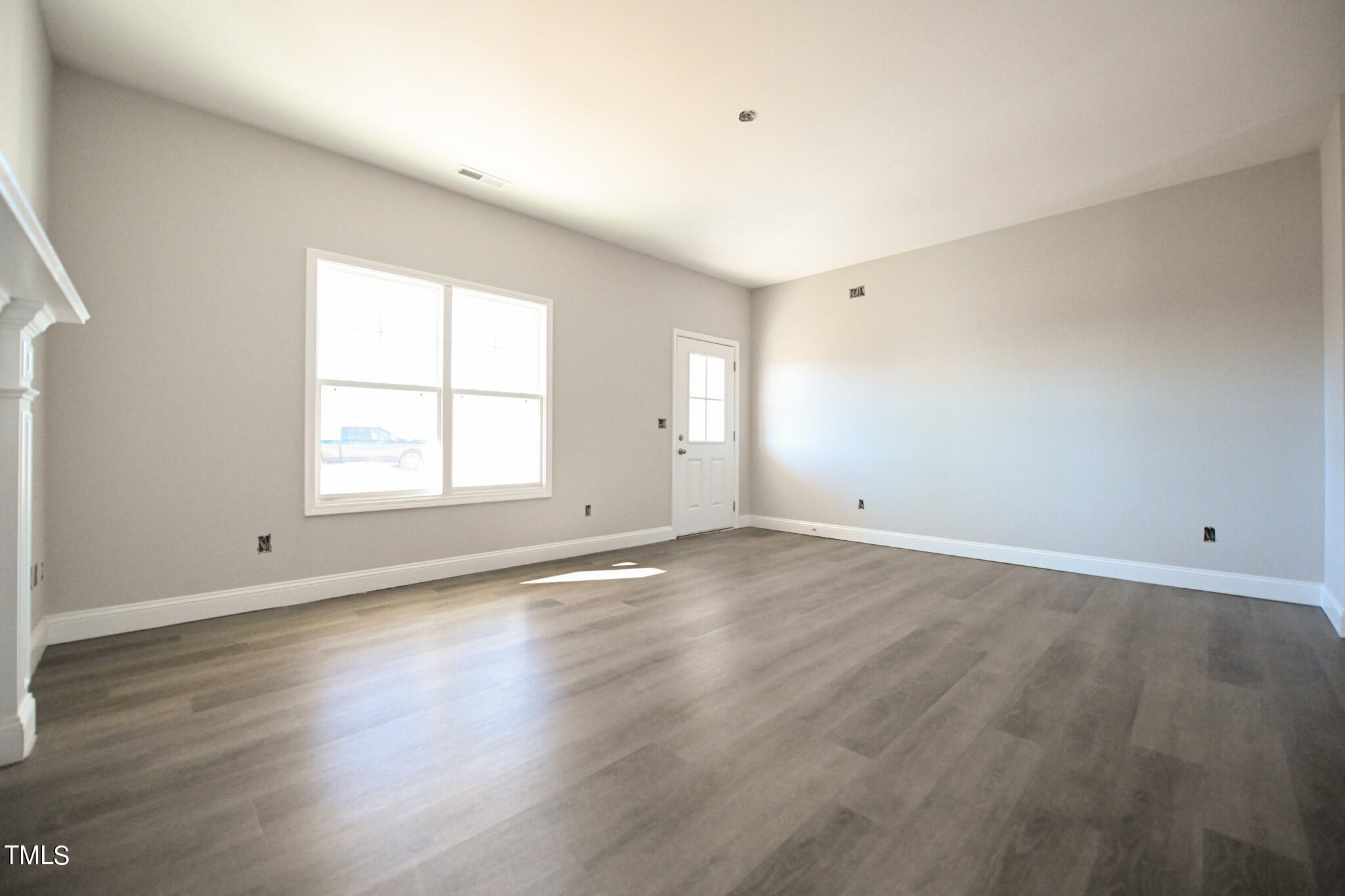 150 Johnson Ridge Way Four Oaks, NC 27524 - Photo 7 of 24 an empty room with wooden floor and windows