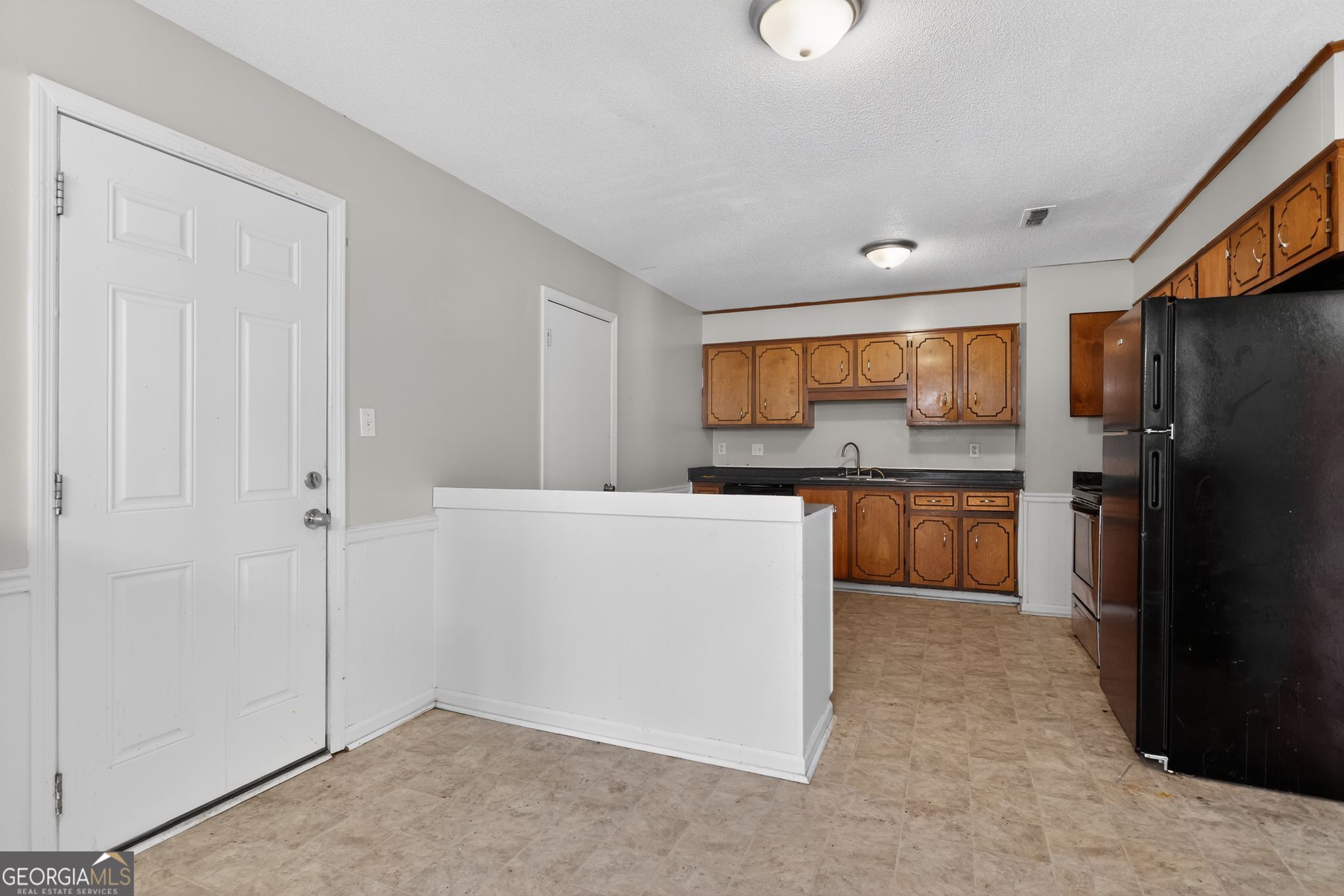 2809 Butler Manor Drive Hephzibah, GA 30815 - Photo 12 of 35 a kitchen with cabinets and a refrigerator