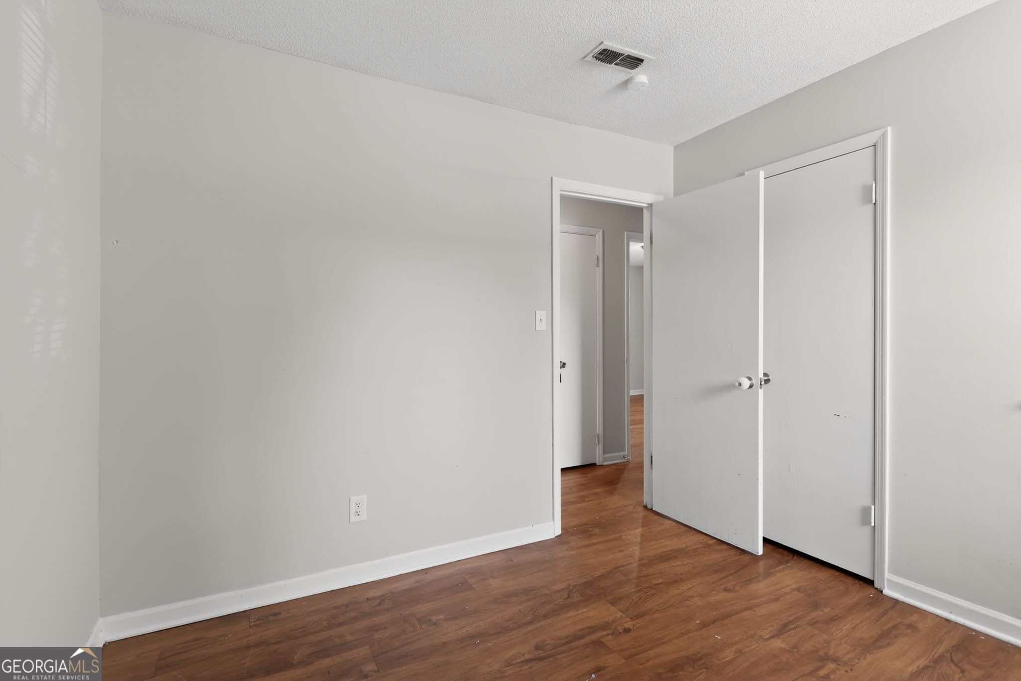 2809 Butler Manor Drive Hephzibah, GA 30815 - Photo 22 of 35 a view of an empty room with wooden floor and a ceiling fan