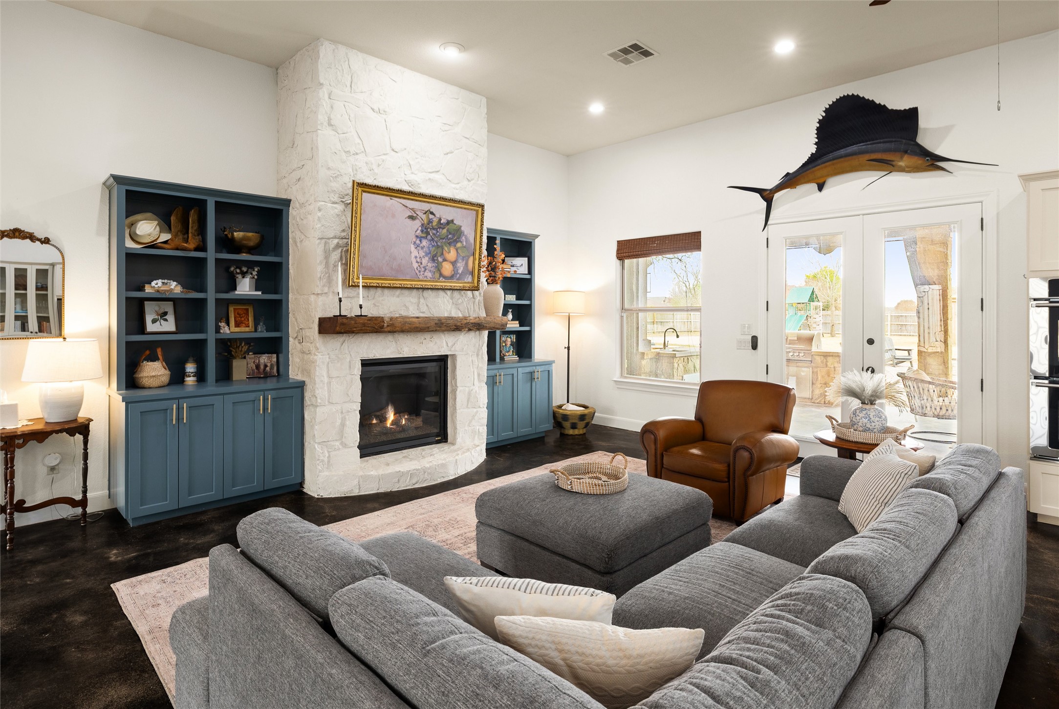 106 Fallow Way Bastrop, TX 78602 - Photo 11 of 40 Living room featuring a stone fireplace flanked with custom built-in shelves