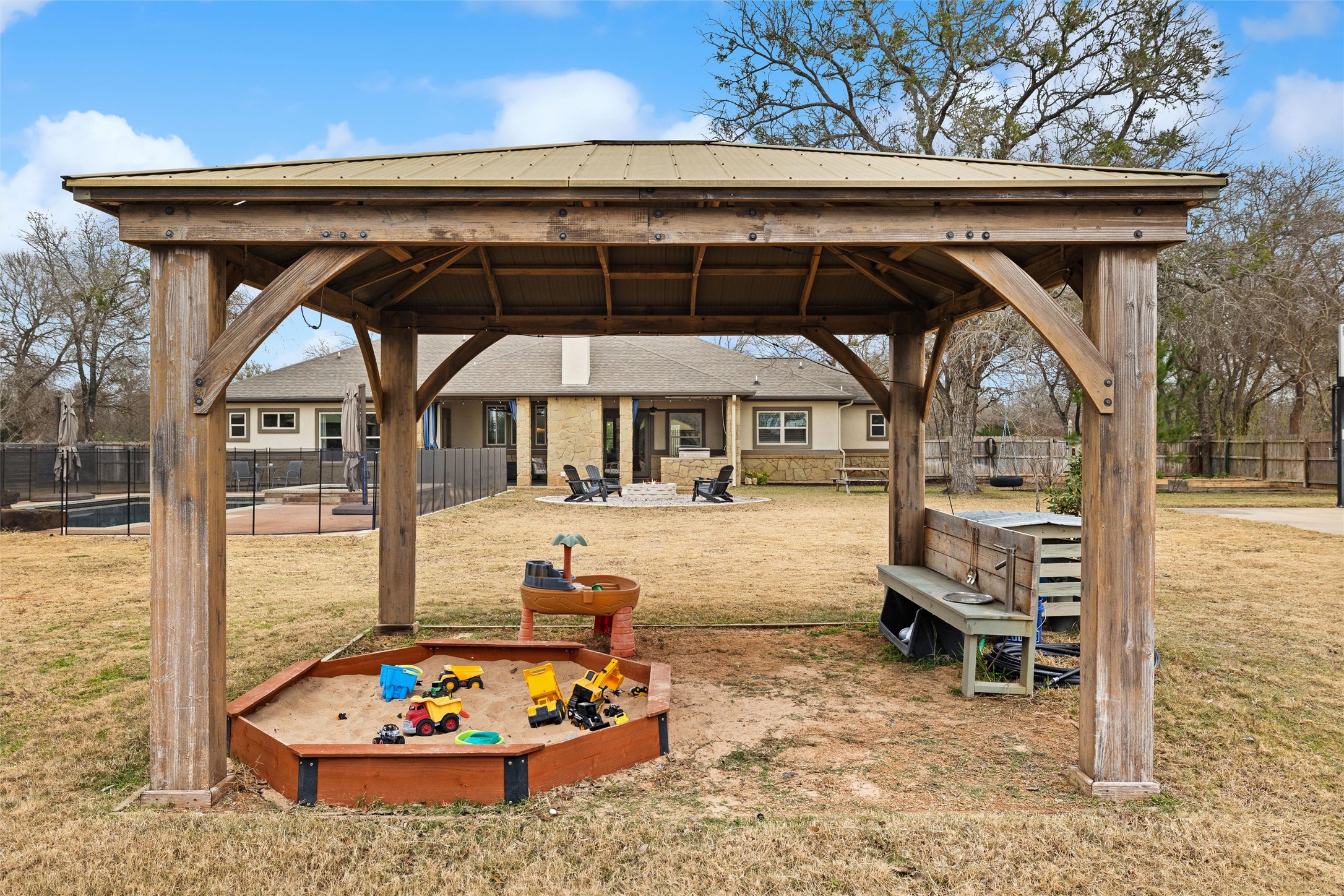 106 Fallow Way Bastrop, TX 78602 - Photo 39 of 40 covered play area with sand pit and outdoor play kitchen attached to the well