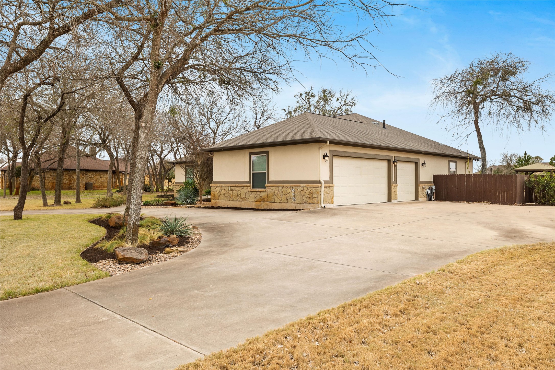 106 Fallow Way Bastrop, TX 78602 - Photo 6 of 40 View of side of property featuring 3-car side entry garage and a circular driveway