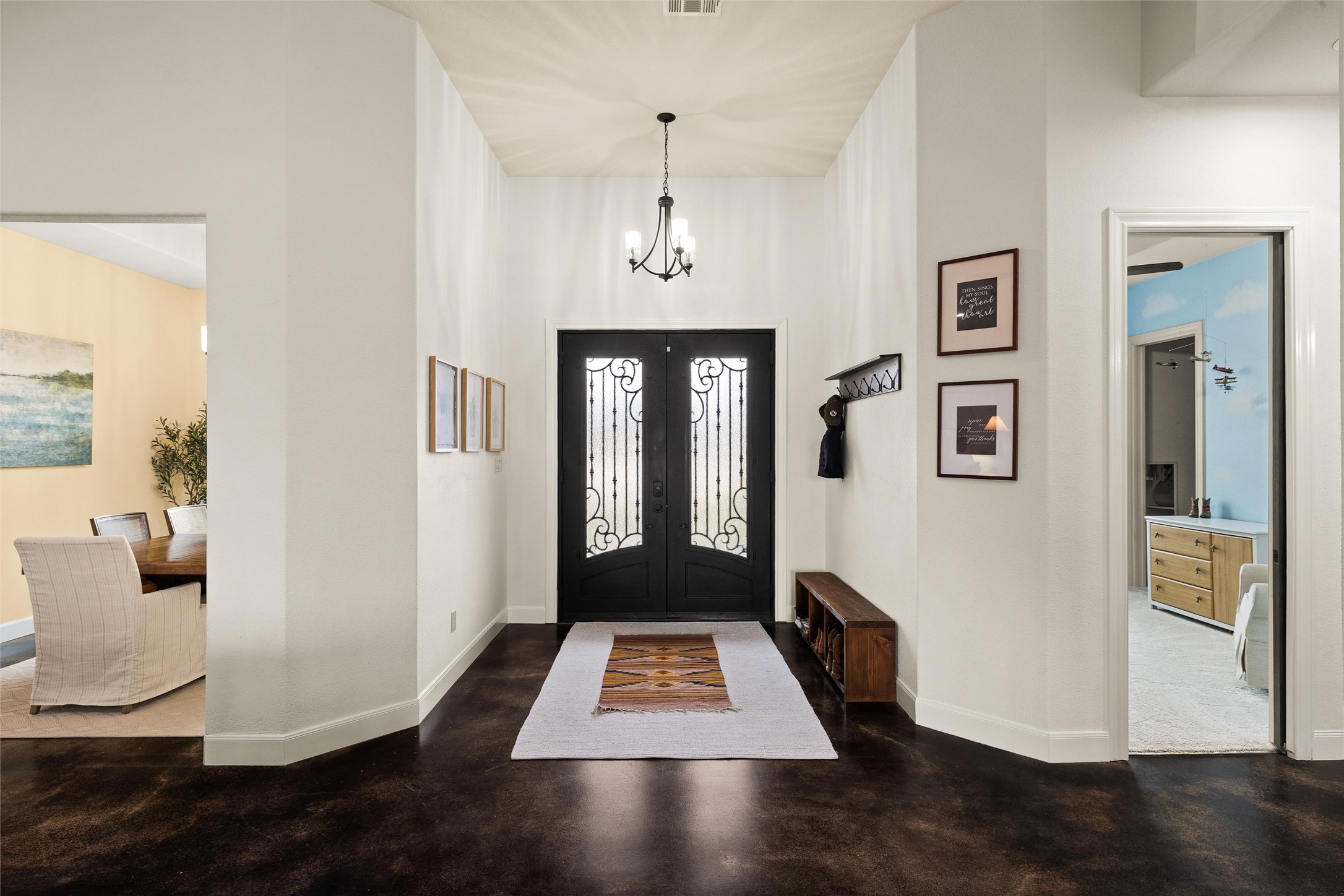 106 Fallow Way Bastrop, TX 78602 - Photo 8 of 40 Wide Foyer with high end double metal doors, concrete floors, a chandelier, and a towering ceiling