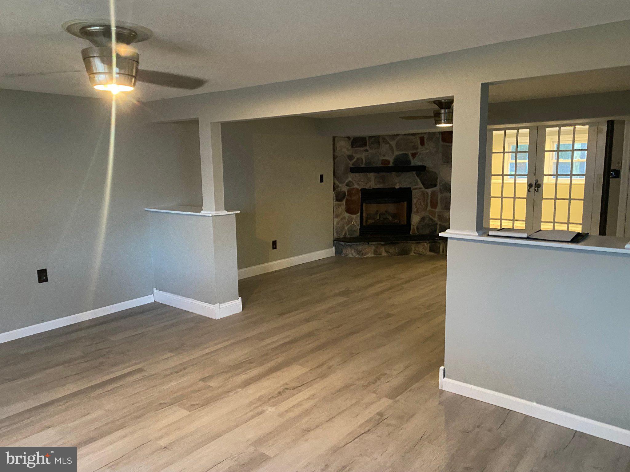 106 Parkview Road Stratford, NJ 08084 - Photo 11 of 27 an empty room with wooden floor fireplace and windows