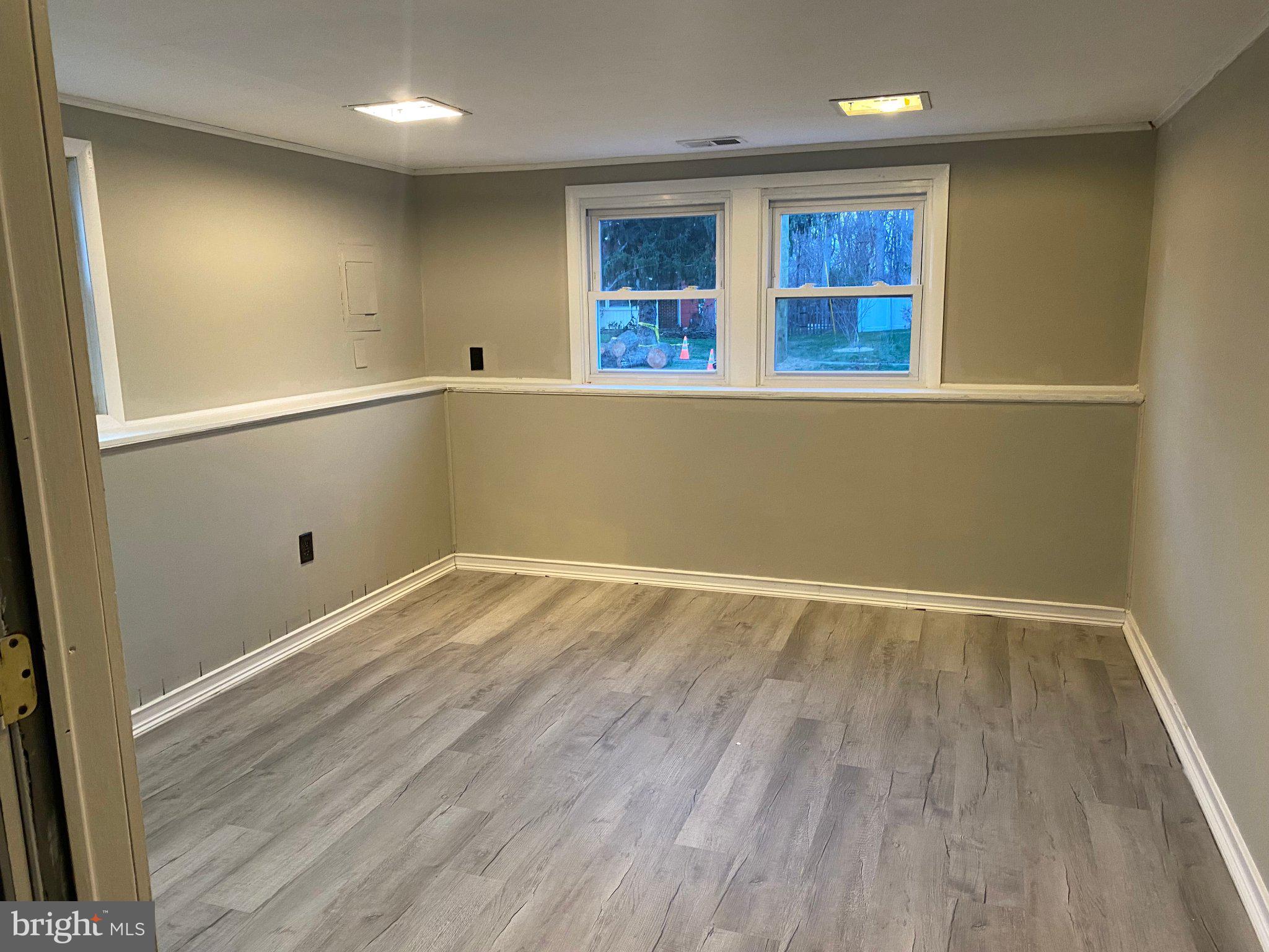 106 Parkview Road Stratford, NJ 08084 - Photo 15 of 27 an empty room with wooden floor and windows