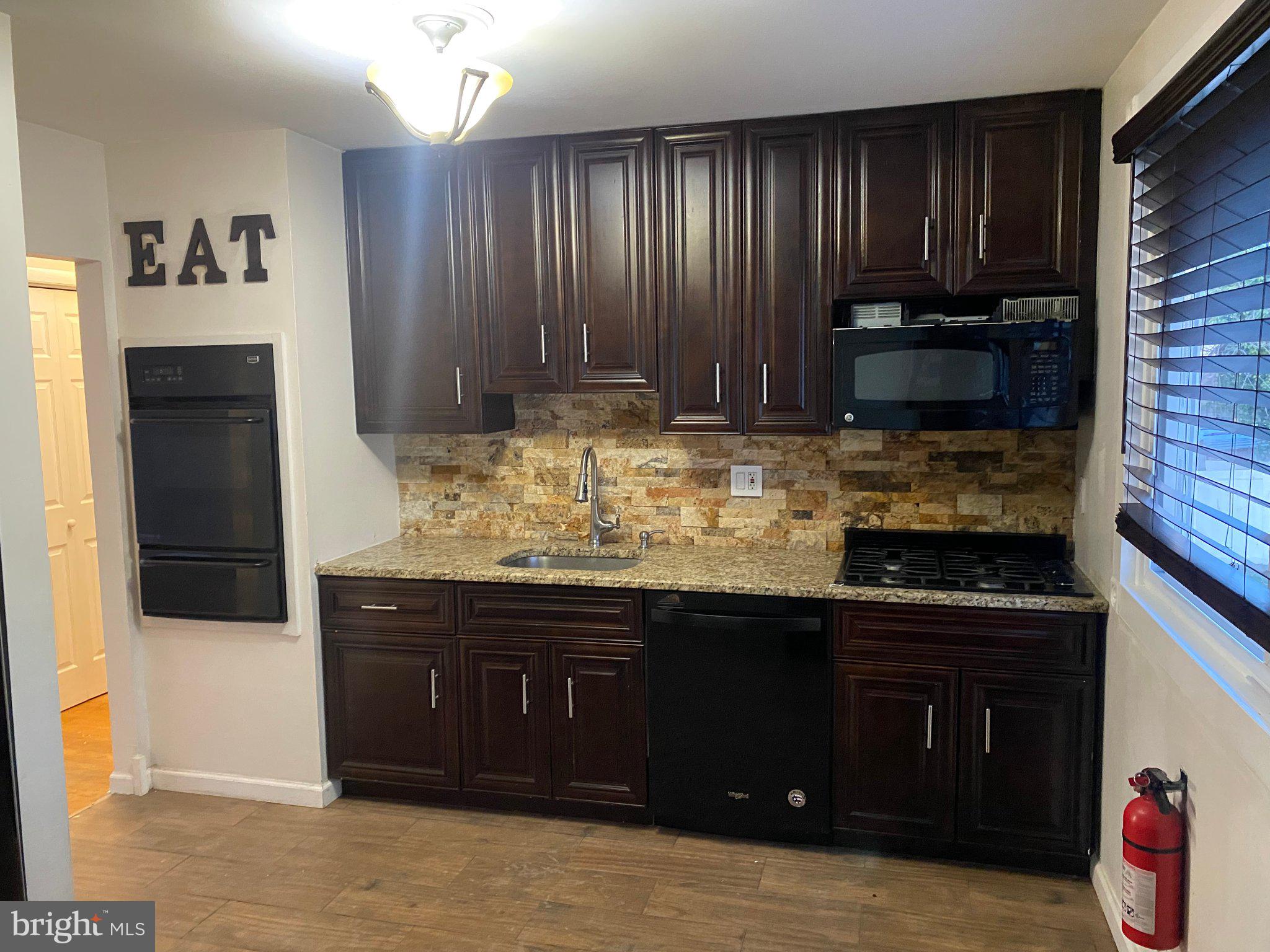 106 Parkview Road Stratford, NJ 08084 - Photo 7 of 27 a kitchen with kitchen island granite countertop wooden cabinets and a sink
