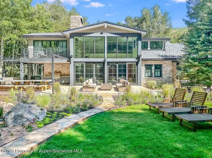 a front view of a house with a garden and lake view