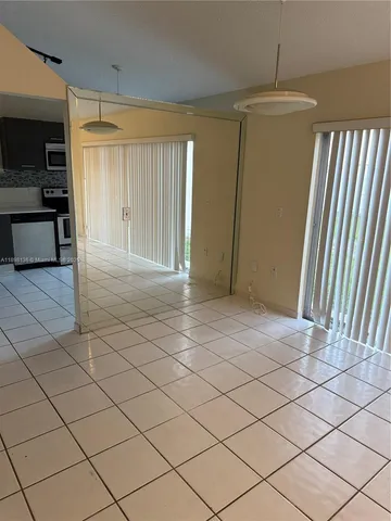 a view of empty room with wooden floor and window