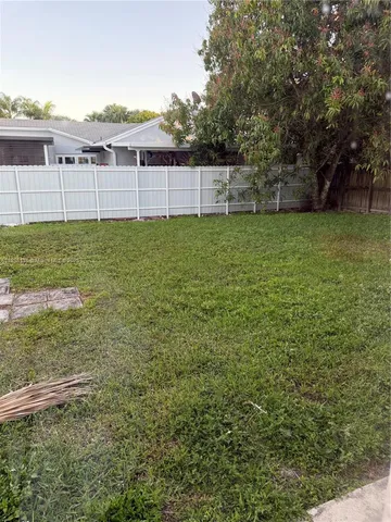 a view of a green field with house in background