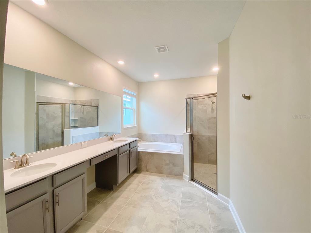 2768 Norway Maple Court Ocoee, FL 34761 - Photo 18 of 35 a large bathroom with a double vanity sink and mirror