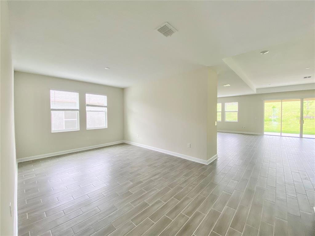 2768 Norway Maple Court Ocoee, FL 34761 - Photo 3 of 35 an empty room with wooden floor and windows